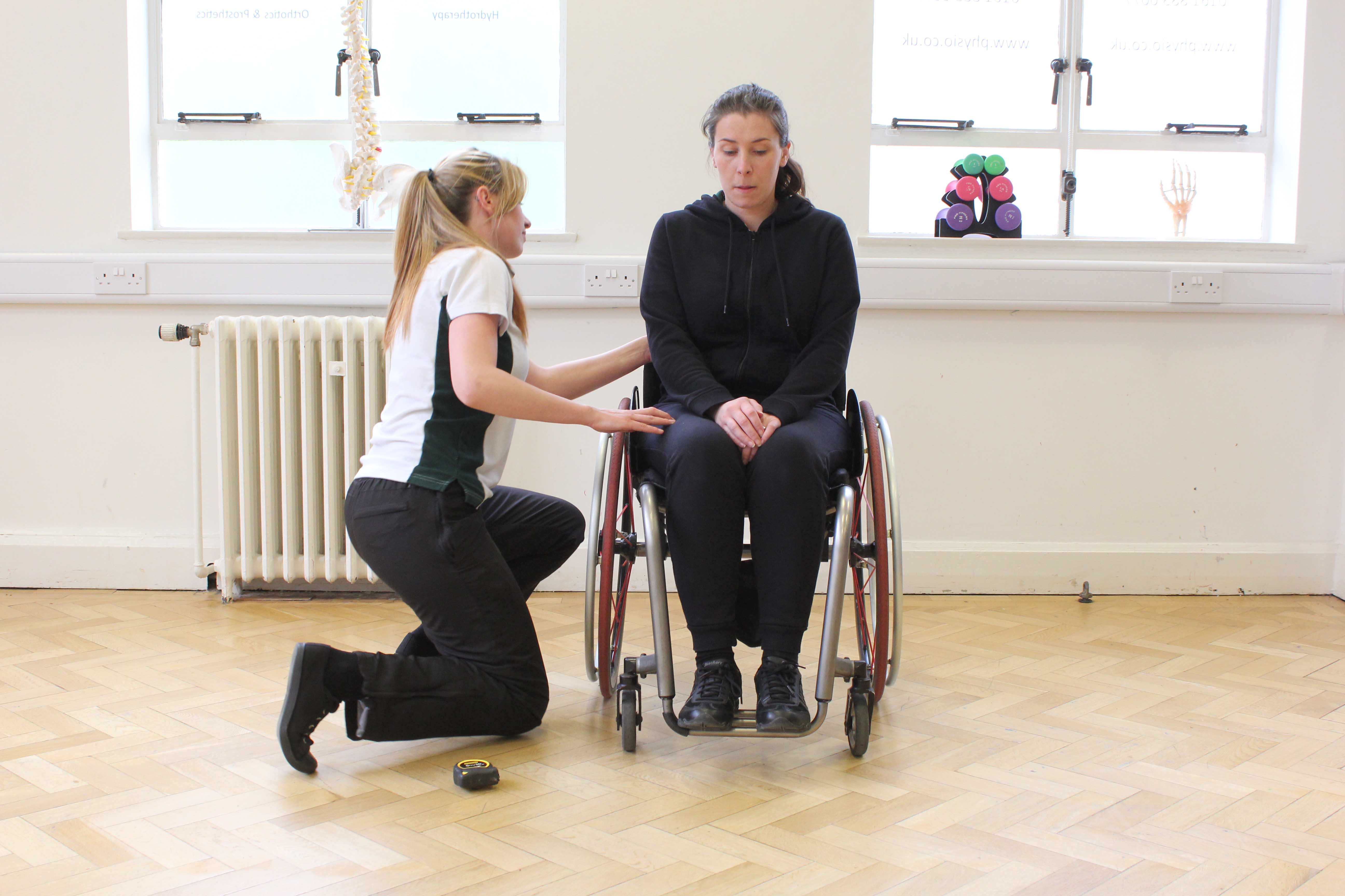 Our physiotherapist ensuring her patients wheelchair is adjusted correctly to support her patients posture.
